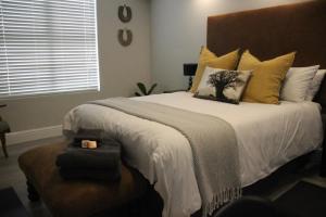 1 dormitorio con 1 cama grande con almohadas amarillas en Madison Views of Table Bay, en Ciudad del Cabo