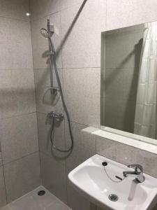 een badkamer met een douche en een wastafel bij The Sarining Hotel in Tabanan