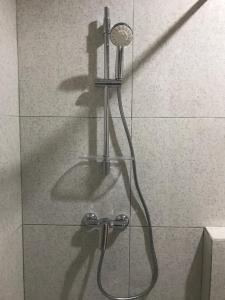a shower with a shower head in a glass wall at The Sarining Hotel in Tabanan