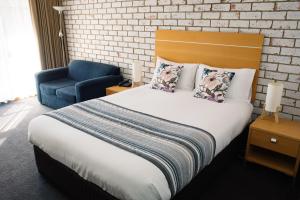 Un dormitorio con una cama grande y una silla azul. en The Heritage Bendigo, en Bendigo 24 fotos más