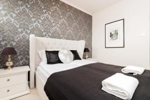 una camera da letto con un letto con un piumone bianco e nero di Apartments Tartaczna 2 - Gdansk Old Town by Renters a Danzica