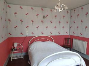 ein Schlafzimmer mit einer roten und weißen Wand mit roten Blumen in der Unterkunft Maison d'Argonne in Brécy-Brières