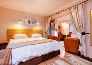 1 dormitorio con 1 cama grande y 1 mesa en Waterkloof Apartments en Pretoria
