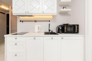 a white kitchen with a sink and a microwave at Apartments Tartaczna 2 - Gdansk Old Town by Renters in Gdańsk