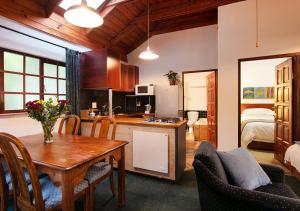 cocina y comedor con mesa y sillas en Waterkloof Apartments, en Pretoria