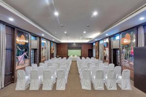 Sala de conferencias con sillas blancas y pantalla de proyección en Club Mahindra Derby Green, Ooty, en Ooty