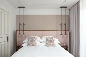 a bedroom with a large white bed with two pillows at The Norman Tel Aviv in Tel Aviv