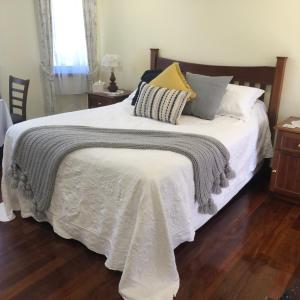 a bedroom with a white bed with pillows on it at The Hideaway Luxury B&B Retreat in Armadale