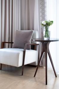 a living room with a white chair and a table at The Norman Tel Aviv in Tel Aviv