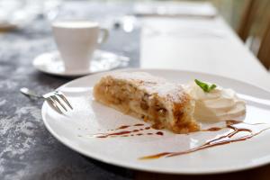 un piatto bianco con un pezzo di torta e panna montata di Sporthotel Olympia a Stachy