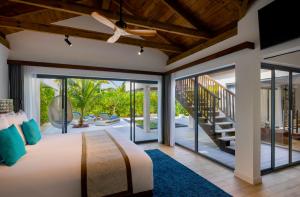 马纳杜岛Kuredhivaru Resort and Spa - Maldives的一间卧室设有床和滑动玻璃门