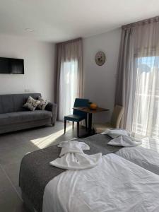a hotel room with two beds and a couch at ElleNapa Apts & Studios in Ayia Napa +171 photos