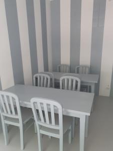 a white table and chairs in a room at ALBERGUE DE CALDAS de REIS Peregrinos y Turistico in Caldas de Reis