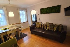 ein Wohnzimmer mit einem schwarzen Sofa und einem Tisch in der Unterkunft Wohnung im Herzen von Ludwigsburg in Ludwigsburg