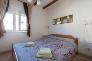 1 dormitorio con 1 cama con toallas en Holiday home Nostalgija en Brgulje