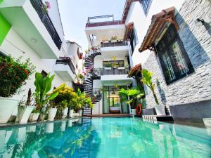 a building with a swimming pool in front of a building at Anh Family Homestay in Hoi An