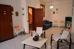 a living room with chairs and a table and a couch at Casa di lu mari in Tre Fontane