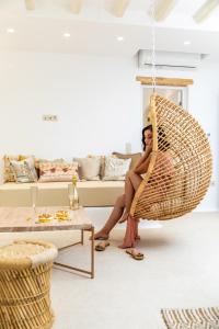 a woman sitting in a hammock in a living room at Villa Gold & White in Maragkas