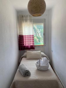 ein kleines Schlafzimmer mit einem Bett und einem Fenster in der Unterkunft Casa Vista Nevada in Güéjar-Sierra