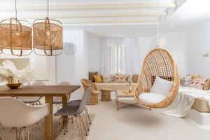 una sala de estar con una silla de mimbre y una mesa en Villa Gold & White, en Maragkas