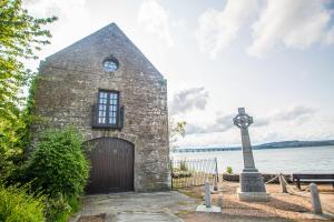 a brick building with a door next to a body of water at The Old Boathouse in Wormit