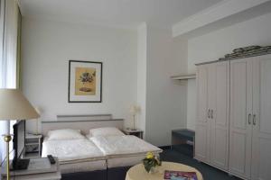 a bedroom with a large bed and a table at Hauptallee Appartements in Bad Pyrmont