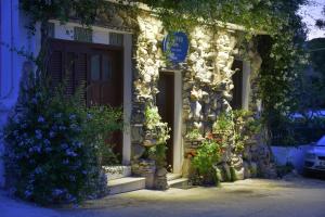 a stone house with flowers in front of it at Bella Vita Style rooms & apartments in Pitsidia