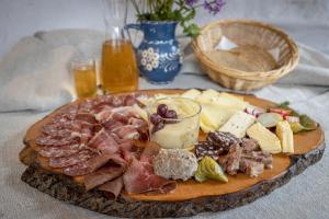 un plato de comida con carne y queso en una mesa en Kräuterpension Rosenkranz, en Rangersdorf