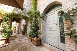 budynek z białymi drzwiami i roślinami w obiekcie Residenza La Corte Assisi w Asyżu