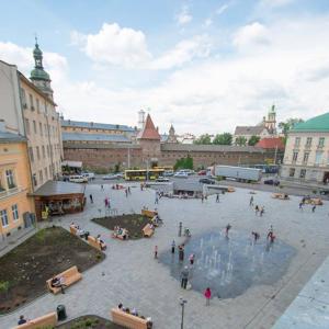 a group of people standing around a fountain in a city at Аpartments in the center (Mytna square) in Lviv
