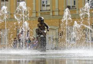 a statue in a fountain in front of a building at Аpartments in the center (Mytna square) in Lviv