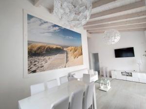 una sala da pranzo con un tavolo bianco e sedie bianche di IKEBANA VILLAS PORTO PINO BEACH a Porto Pino