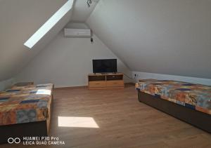 a attic bedroom with two beds and a tv at Gästewohnung 17 in Oschersleben