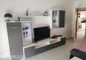 a living room with a entertainment center with a flat screen tv at Gästewohnung 17 in Oschersleben