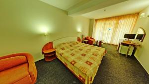 Habitación de hotel con cama, sofá y escritorio en Hotel Exotica en Golden Sands
