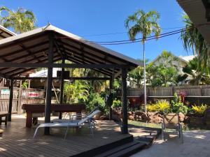a wooden deck with a picnic table and a bench at Kimberley Travellers Lodge in Broome +17 photos