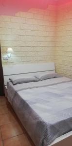 łóżko w pokoju z ceglaną ścianą w obiekcie b&b ERCOLANO Scavi w mieście Ercolano