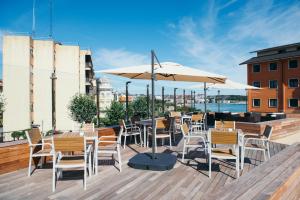 a patio with tables and chairs and an umbrella at Gran Hotel Victoria in Santander