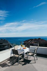 una mesa y sillas en un balcón con vistas al océano en Gran Hotel Victoria, en Santander
