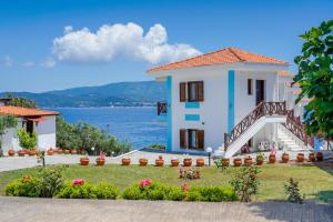 ein Haus mit Blick auf das Wasser in der Unterkunft Pansion Limanaki in Amolianí