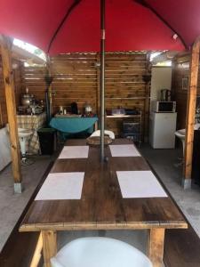 a kitchen with a wooden table in a tent at Le sang des vignes in Monbazillac