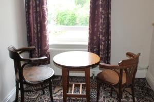 a dining room table and chairs in front of a window at Olympia Hotel in Selby