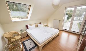 Un dormitorio con una gran cama blanca y dos ventanas. en Fewo Meeresrauschen, en Thiessow