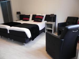 een slaapkamer met een bed en een stoel bij B&B OpdeParkkamp met laadpaal voor elektrische auto's in Havelte