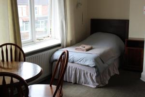 a bedroom with a bed, chair and a window at Olympia Hotel in Selby