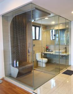 a bathroom with a glass shower and a toilet at Eve Suite in Petaling Jaya