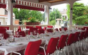 a long table with red chairs and wine glasses on it at Apartmani Selina in Jadranovo