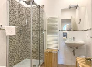a bathroom with a glass shower and a sink at GH Paradiso - Apartments in Siena +66 photos