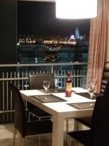 uma mesa com copos e uma garrafa de vinho na varanda em Torresol em Benidorm