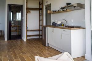 kuchnia z białymi szafkami i drewnianą podłogą w obiekcie Laura maisons w Kalamácie +18 zdjęć
